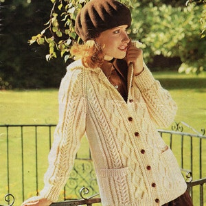 May include: A magazine cover showing a woman in a cream cable-knit cardigan with brown buttons and pockets, and a brown beret. The cardigan is part of an Aran knitting pattern. The magazine title "SUNBEAM" is at the top, with bust measurements.