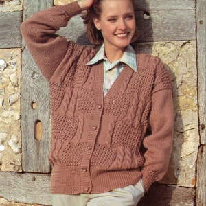 May include: A brown cable knit cardigan with a button front and a white collared shirt underneath.