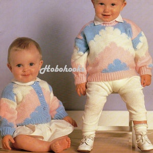 May include: Two babies wearing knitted sweaters with a cloud design. The sweater on the left is blue, pink, and white. The sweater on the right is pink, blue, and white. Both sweaters have a button closure.