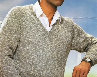 May include: A light gray sweater with a V-neck and a textured knit. The sweater is worn by a person with dark hair and a white shirt underneath.
