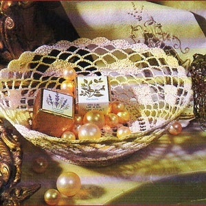 May include: A crocheted doily bowl filled with pearl-like beads and two small boxes of soap. One box is labeled "Gardenia" and the other is labeled "Lavender".