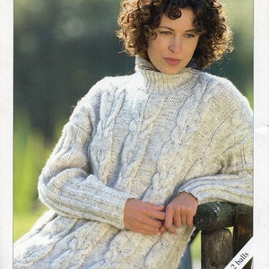 May include: A white cable knit jumper with a high neck. The jumper is made with a chunky yarn and has a relaxed fit. The text "Only takes 2 balls" is visible in the bottom right corner of the image.