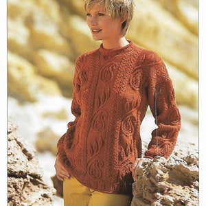 May include: A rust-coloured knitted jumper with a paisley pattern. The jumper has a round neckline and long sleeves.