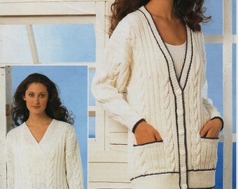 May include: White cable knit cardigan with a V-neck, navy blue trim, and two pockets. The cardigan is shown on a model with a white background.