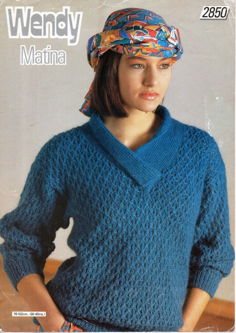 May include: A blue knitted sweater with a V-neck and a geometric pattern. The sweater is worn by a person wearing a colorful headscarf. The pattern number 2850 is visible in the top right corner of the image.