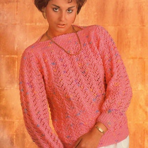 May include: A pink knitted sweater with a square neckline. The sweater has long sleeves and is decorated with small, colorful flecks. The image also includes the measurements: 28-38 inches.