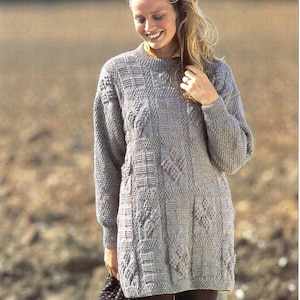 May include: A gray knitted sweater with a textured pattern. The sweater has a round neckline and long sleeves.