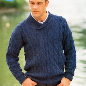 Könnte beinhalten: Ein blauer Strickpullover mit einem breiten, umgeklappten Kragen. Der Pullover hat einen V-Ausschnitt und ist aus weichem, strukturiertem Garn gefertigt.