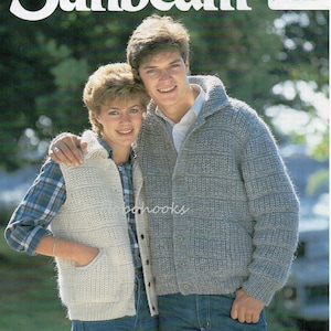 May include: A couple wearing knitted sweaters. The woman is wearing a white vest with a pocket and the man is wearing a gray cardigan with a button closure. The man's sweater has a textured pattern. The couple is standing in a grassy field. The image includes the text "Sunbeam" and "703 Tundra 86-112 cm bust/ 34-44 ins chest".