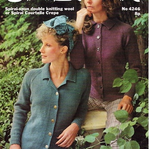 Puede incluir: Dos mujeres con cárdigans de punto. La mujer de la izquierda lleva un cárdigan de color turquesa con cierre de botones y la mujer de la derecha lleva un cárdigan morado con cierre de botones. Ambas mujeres están de pie frente a un fondo verde frondoso.