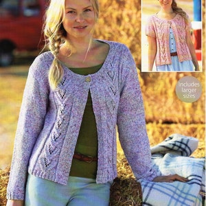 Könnte beinhalten: Ein lila-weiß gestrickter Cardigan mit einem Spitzenmuster. Der Cardigan hat einen runden Ausschnitt und einen Knopfverschluss. Das Model trägt den Cardigan mit einem grünen Shirt und einer blauen Jeans. Das Bild enthält den Text "81/86-132/137cm 32/34-52/54" und "Enthält größere Größen".