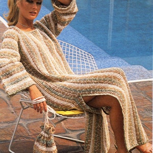 May include: A woman wearing a long, striped crochet dress with a side slit. She is sitting on a white chair by a pool and holding a crocheted bag.