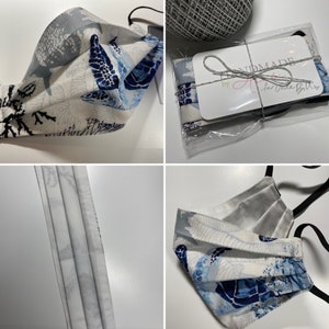 May include: A white face mask with a blue and white sea turtle pattern. The mask is folded and has black elastic ear loops. The mask is packaged in a clear plastic bag with a white tag that says "Handmade by A for Uncle Bill's".