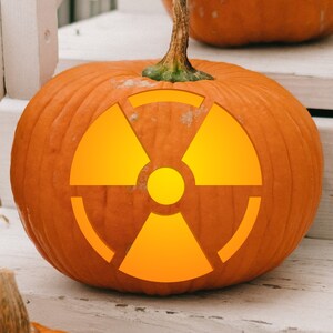 May include: A carved pumpkin with a bright yellow radiation symbol. The pumpkin is orange and has a green stem.
