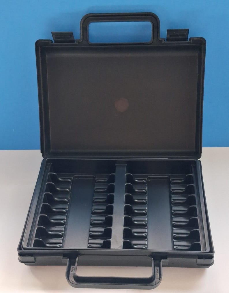 May include: An open, black plastic carrying case with a handle on top and a latch. The interior is divided into compartments, likely for organizing small items. The case is designed for easy transport and storage.