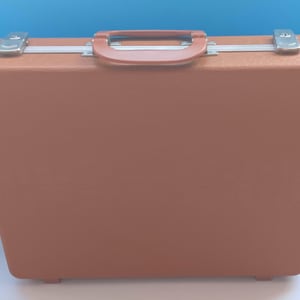 May include: A brown vintage briefcase with a matching handle and silver-colored metal clasps. The briefcase has a rectangular shape and is set against a blue background.