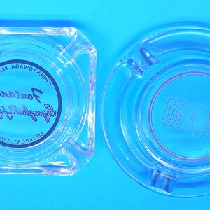 May include: A square clear glass ashtray with the text Fontana's Spaghetti House, Cheektowaga: 822-7918, Lockport: 433-4445 printed in black, and a round clear glass ashtray with the letters K and V separated by a star symbol etched in the center.