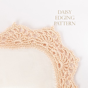 May include: A close-up of a crocheted daisy edging pattern. The edging is a light cream color and has a delicate, lacy design.
