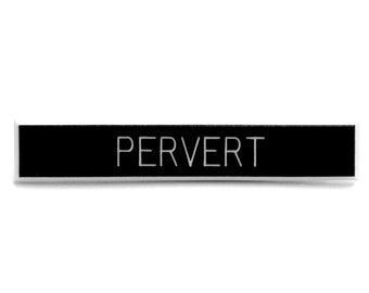 May include: A black rectangular sticker with the word "PERVERT" printed in white, centered on the sticker. The sticker is set against a white background.