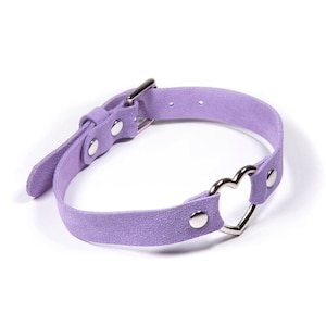 Lavender suede choker with a silver heart shaped ring in the middle. With a buckle closure and silver rivets holding it together.