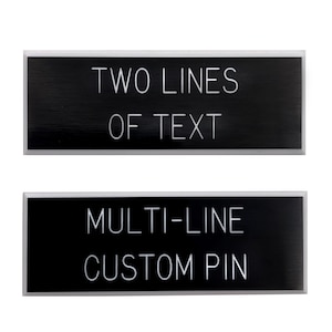 May include: Two black metal name tags with silver trim. The top tag says "TWO LINES OF TEXT". The bottom tag says "MULTI-LINE CUSTOM PIN".