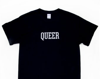 May include: Black t-shirt with the word "QUEER" printed in white block letters. The shirt is a basic crew neck style, with short sleeves. The text is centered on the chest.