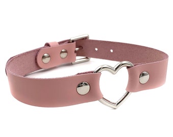 May include: A pink leather choker with a silver heart-shaped ring and silver studs.