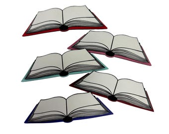 May include: Five open book-shaped items with white pages and black spines. The covers are red, pink, teal, burgundy, and blue. The books are arranged at different angles, suggesting a playful or decorative arrangement.