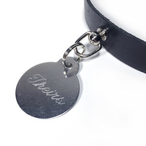 May include: A black leather collar with a silver tag that says "Theirs" engraved on it.