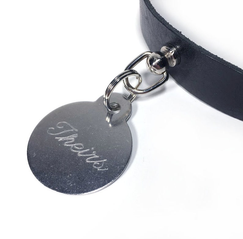 May include: A black leather collar with a silver tag that says "Theirs" engraved on it.
