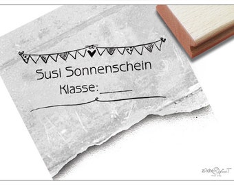 May include: Black and white illustration of a string of party flags with a heart in the middle. The text "Susi Sonnenschein" and "Klasse:" is below the flags.