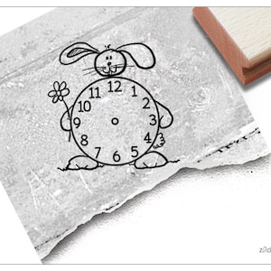 Puede incluir: Un dibujo en blanco y negro de un conejo sosteniendo un reloj con los números del 1 al 12. El conejo sostiene una flor en su otra mano.