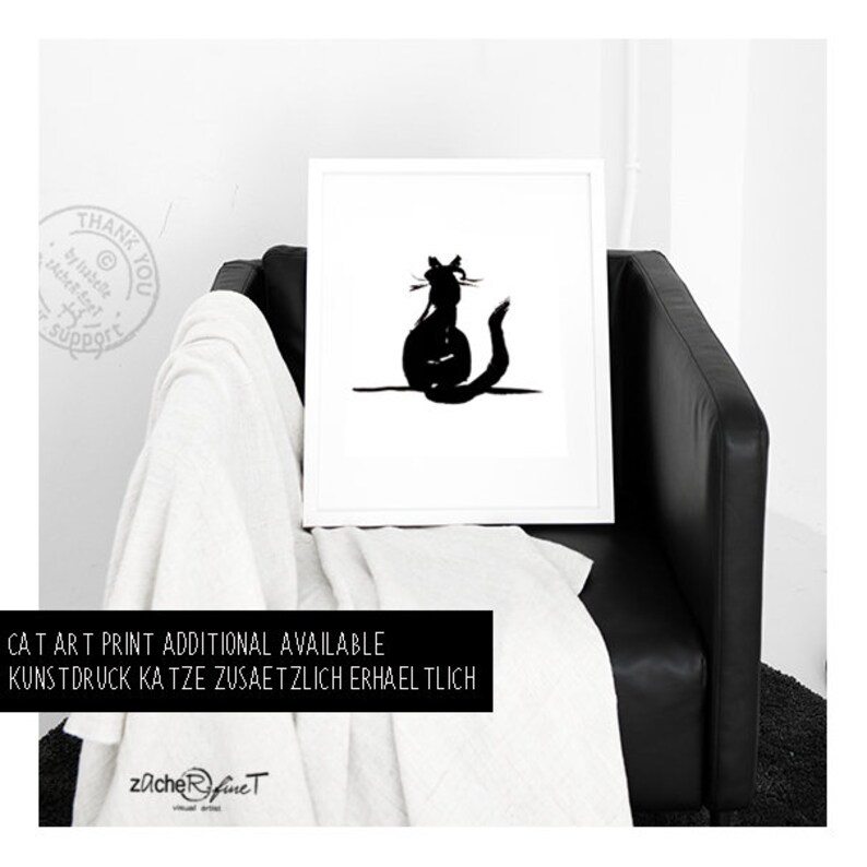 May include: A monochrome cat art print in a white frame. The image shows a black silhouette of a cat. The framed print is on a black leather chair with a white throw. Text at the bottom reads "CAT ART PRINT ADDITIONAL AVAILABLE".