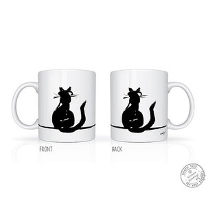 May include: White ceramic mug with a black cat silhouette design. The cat is illustrated in a minimalist style, with a long tail and whiskers. The mug has a curved handle and a simple design, ideal for tea or coffee.