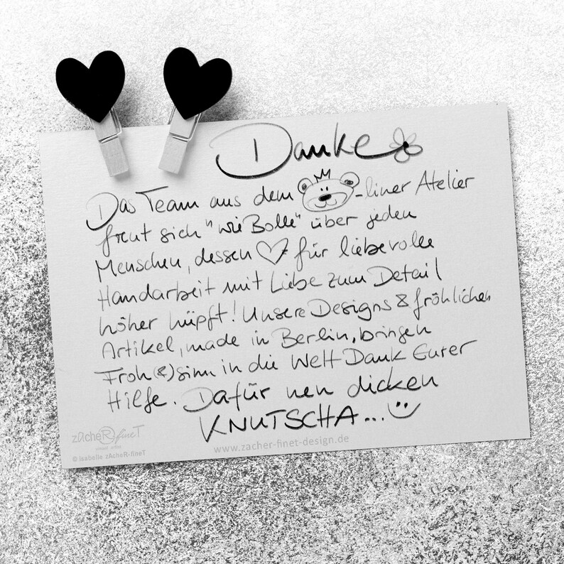 May include: A handwritten thank you note with a black and white illustration of a bear wearing a crown. The note says "Danke" and "Das Team aus dem ... liner Atelier freut sich "wir Bolle" &uuml;ber jeden Menschen, dessen ... f&uuml;r liebevolle Handarbeit mit Liebe zum Detail ... hsher h&uuml;pft! Unsere Designs & fr&ouml;hlichen Artikel, made in Berlin, bringen Froh(e)sinn in die Welt Dank Gurer Hilfe. Daf&uuml;r nen dicken KNUTSCHA..." and "zacher fineT Isabelle Zacher-Finet www.zacher-finet-design.de".