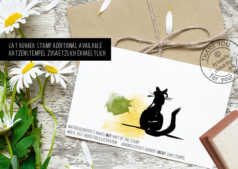 May include: A black cat rubber stamp design with watercolor effect, on a white card. The card has text that says "Thank you for your" and "Cat rubber stamp additional available". Daisies and a brown envelope with twine are in the background.