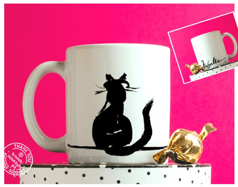 May include: White ceramic mug with a black cat silhouette. The cat is depicted sitting with its tail curled. The mug has a curved handle and is set against a bright pink background.