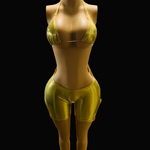May include: A gold metallic two-piece swimsuit with a halter top and shorts.