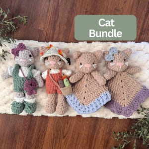 May include: A set of four crocheted cat toys including two standing figures with outfits and accessories, and two cat-shaped security blankets. The figures feature soft yarn textures in shades of gray, tan, orange, and green with embroidered details.