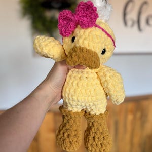 Handmade crochet duck plush with pink bow and fluffy feather detai