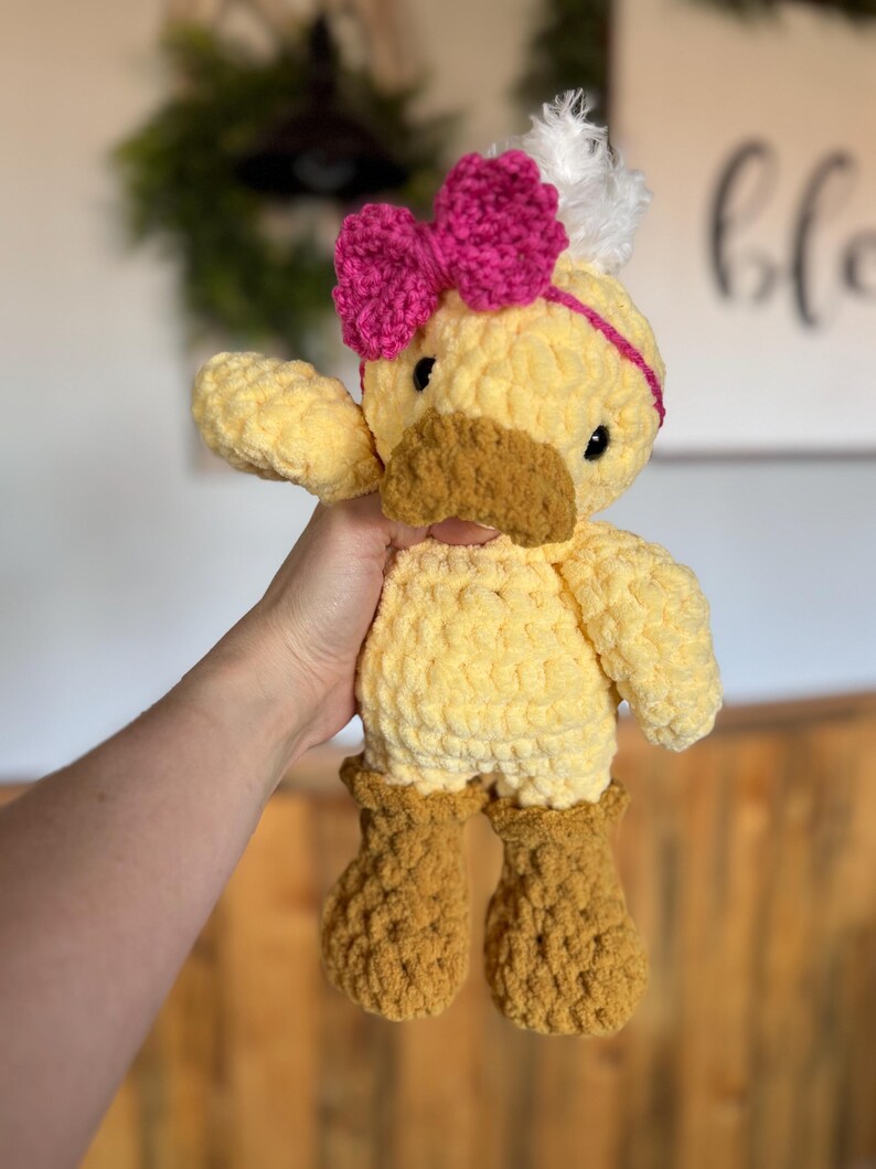 Handmade crochet duck plush with pink bow and fluffy feather detai
