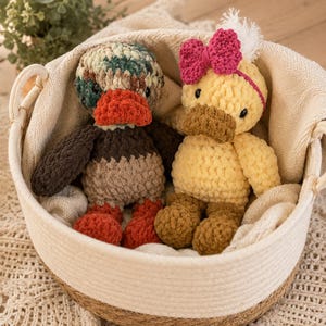 Crochet duckie pattern with yellow duck and mallard duck displayed in neutral basket
