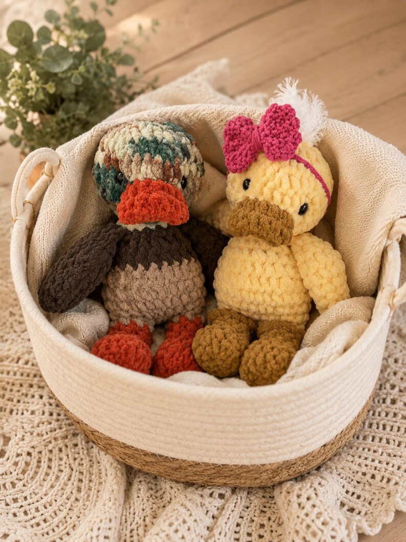 Crochet duckie pattern with yellow duck and mallard duck displayed in neutral basket