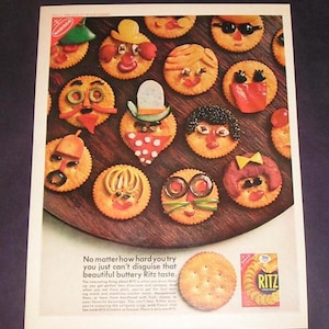 May include: An advertisement featuring Ritz crackers decorated with various food items to resemble faces. The crackers are arranged on a wooden surface. The text reads, "No matter how hard you try you just can't disguise that beautiful buttery Ritz taste."