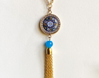 Long gold beaded necklace with blue floral and rhinestone cabochon tassel pendant