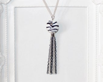 Long silver necklace with black and white zebra print focal bead and tassel