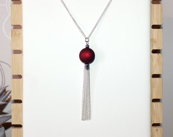 Long silver necklace with burgundy red focal bead and tassel pendant