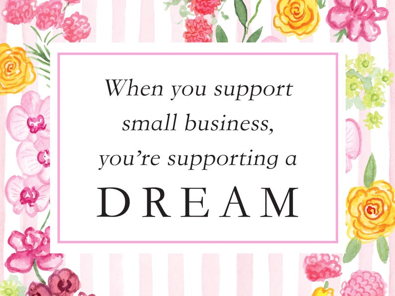 May include: A rectangular sign with a white background and light pink vertical stripes, framed by watercolor flowers in shades of pink, yellow, and green. The text reads: When you support small business, you&rsquo;re supporting a DREAM.