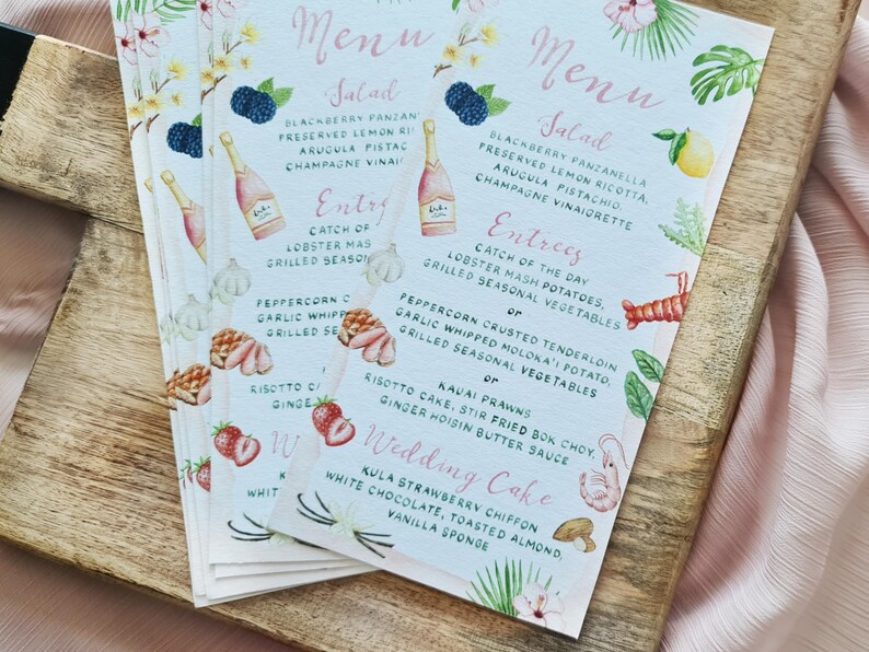 May include: A wedding menu with a tropical theme. The menu features a salad, entrees, and a wedding cake. The menu is written in a cursive font and is decorated with watercolour illustrations of flowers, fruit, and leaves.