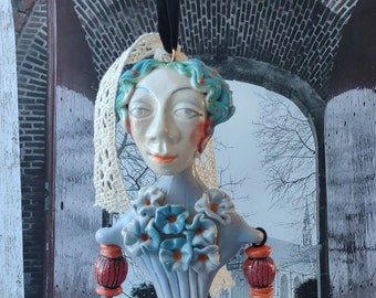 Clay art doll. Dangling doll sculpted from stoneware pottery clay. Dressed in baroque style in puffy pants with flounces and ruffles.